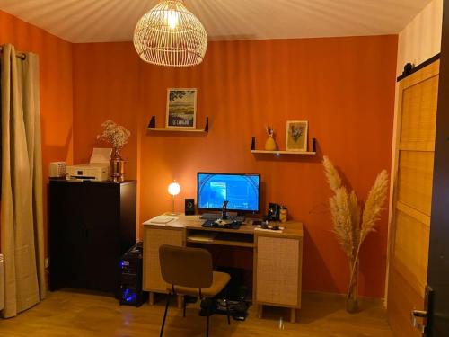 uma sala laranja com uma secretária com um computador em Villa avec piscine dans le sud de la France em Saleilles