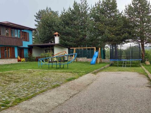 a yard with two playground equipment in front of a house at Вила Боби in Tsigov Chark