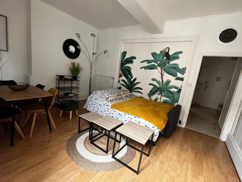 a bedroom with a bed with a yellow blanket at Appartement centre ville in Fontainebleau