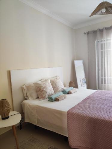 a white bedroom with a bed and a table at Casa Brisa do Mar in Porches