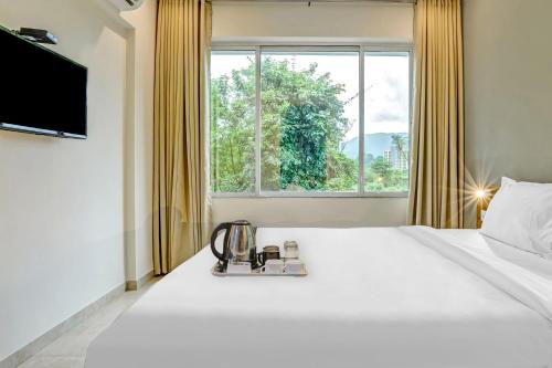 a hotel room with a large white bed and a window at Townhouse 82843 Hotel Somani in Āpta