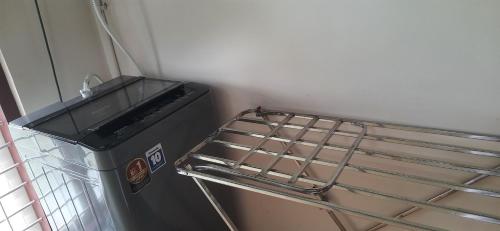 a trash can sitting next to a metal rack at NEST Mdy in Mananthavady
