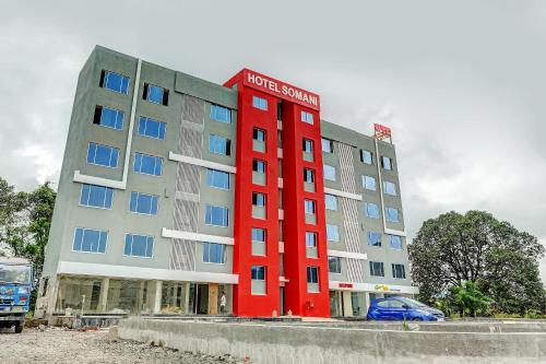 a red building with a blue car in front of it at Townhouse 82843 Hotel Somani in Āpta