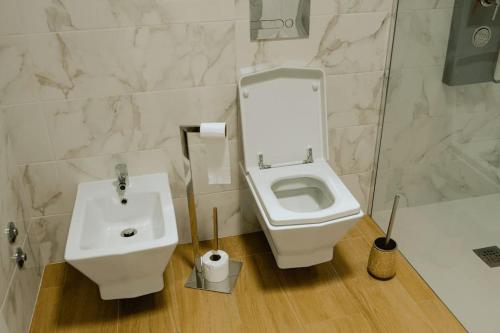 La salle de bains est pourvue de toilettes blanches et d'un lavabo. dans l'établissement Avenida House a 700 metros da praia, à Esposende