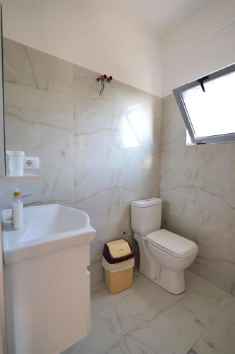 a white bathroom with a toilet and a sink at Tropikal Freskia Bunec in Piqeras