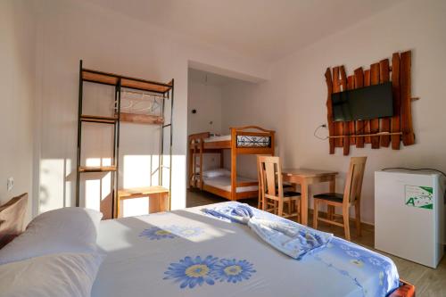 1 dormitorio con 1 cama y comedor con mesa en Tropikal Freskia Bunec, en Sarandë