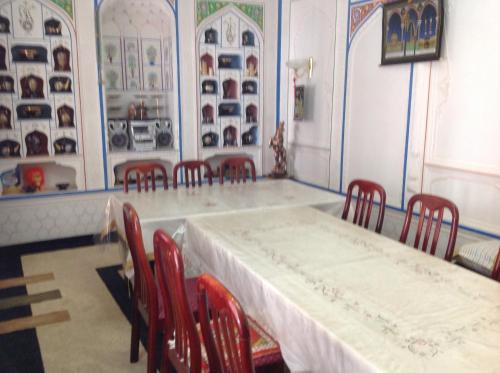 a dining room with a table and red chairs at Hotel Nazira & Azizbek in Bukhara