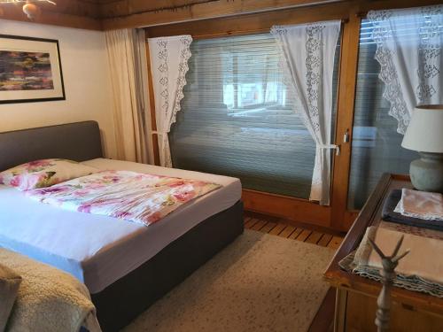 DreamlandRanch Vorarlberg في Schlins: غرفة نوم بسرير ونافذة وطاولة