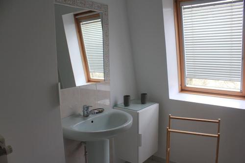Baño blanco con lavabo y espejo en Maison de centre-ville avec grande terrasse en Concarneau