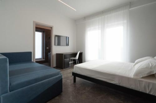 a bedroom with a bed and a desk in it at Hotel Mhami in Pulsano