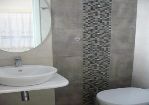 y baño con lavabo, aseo y espejo. en Panorama, en Amorgós