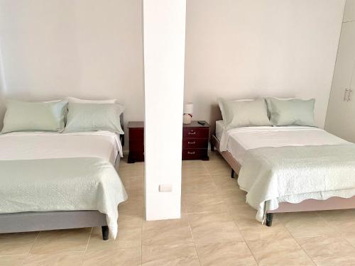 two beds sitting next to each other in a room at Beautiful 2 bedroom, pool, beach in Manta