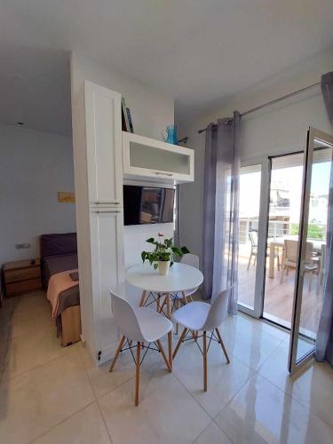 un tavolo bianco con sedie in una camera con balcone di Ethereum City Αpartment - Suite a Chania