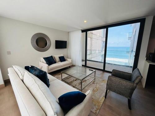 a living room with a white couch and a large window at En Malecón con vista al mar y lago by G P S rentas in Mazatlán