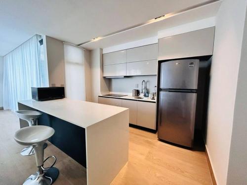 a kitchen with a white counter and a refrigerator at En Malecón con vista al mar y lago by G P S rentas in Mazatlán