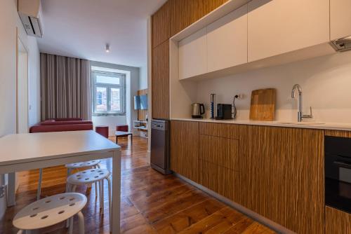 a kitchen with wooden cabinets and a counter top at Liberdade Concept 2BDR Apartment by LovelyStay in Lisbon