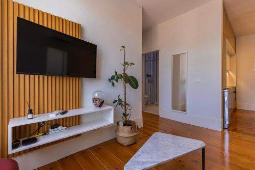 a living room with a flat screen tv on a wall at Liberdade Concept 2BDR Apartment by LovelyStay in Lisbon