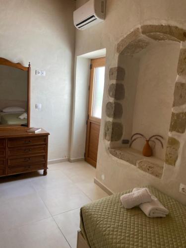 a bedroom with a bed and a stone wall at Avli House Vori in Vóroi