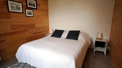 a bedroom with a white bed with two pillows on it at La Sapinière St Lary Soulan in Saint-Lary-Soulan