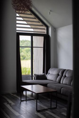 a living room with a couch and a large window at Utriai Guest Place in Utriai
