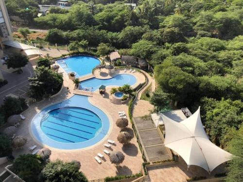 - une vue sur la piscine bordée de chaises et d'arbres dans l'établissement Santa Marta Apartamento Bello Horizonte Zazué, à Santa Marta
