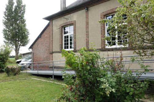 a brick house with two windows on the side of it at Gîte au cœur d'une résidence d'artiste in Saint-Aubin-de-Bonneval