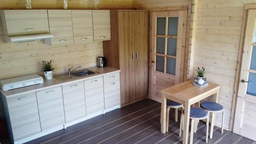 a kitchen with a sink and a table and chairs at Sielankowo Trzęsacz in Trzęsacz