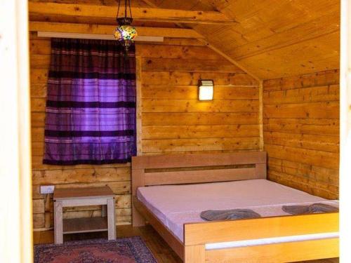 um quarto com uma cama num chalé de madeira em Vikendice Moskva Uvac em Sjenica