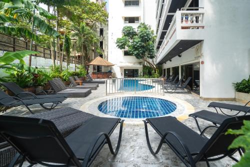a patio with chairs and a swimming pool at Patong Central Hotel & Apartment in Patong Beach