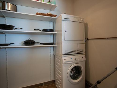 a kitchen with a washing machine and a washer at Goudvis in Cadzand-Bad