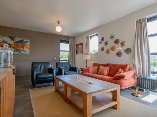 a living room with a couch and chairs and a table at Goudvis in Cadzand-Bad