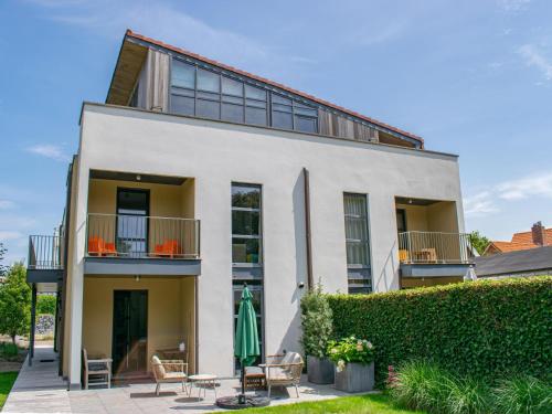 a white house with a patio and a hedge at Goudvis in Cadzand-Bad