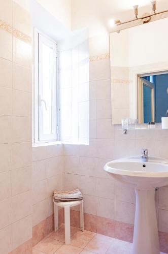 a white bathroom with a sink and a window at Hotel St. James in Florence