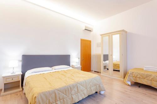 a white room with a bed and a mirror at Hotel St. James in Florence