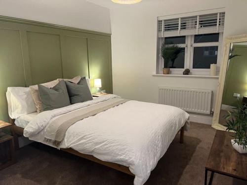 a bedroom with a large white bed and a window at Stunning Home in Astley in Tyldesley