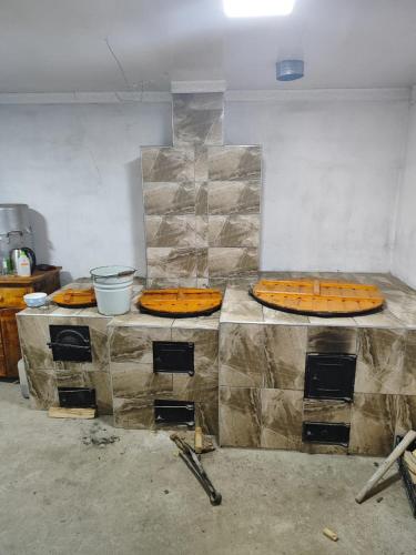 three pizzas sitting on a counter in a kitchen at Guest house SANAT in Naryn