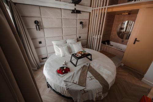 a bedroom with a large white bed with a table on it at DISNEY MOOD BY WELOVEYOU® in Bailly-Romainvilliers