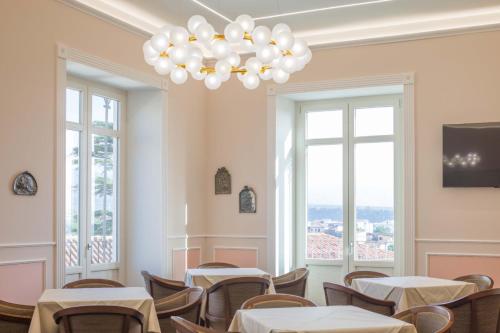 a dining room with tables and chairs and a chandelier at Le Corti - Dimora storica in Polistena