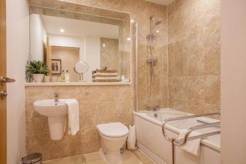 uma casa de banho com um lavatório, um WC e uma banheira em 1 Bedroom Flat in the Heart of Merchant City em Glasgow