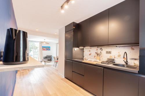 une cuisine avec des armoires noires et un comptoir dans l'établissement Le POP FLAT by Winkyhouse Cassis, à Cassis