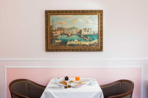 a table with food on it with a painting on the wall at Le Corti - Dimora storica in Polistena