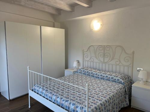 a bedroom with a white bed and a white cabinet at Nei castagni in Levanto