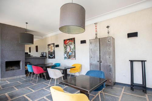 une salle à manger avec des tables et des chaises colorées dans l'établissement Dar Tifrouine, à Lalla Takerkoust