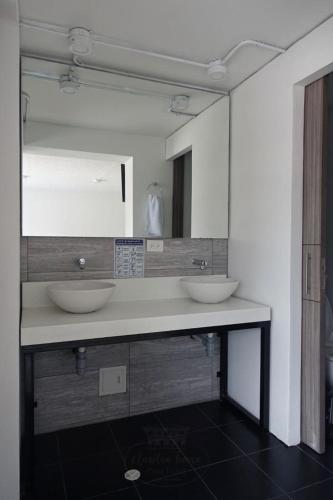 a bathroom with two sinks and a large mirror at CASA HOTEL NUESTRA TIERRA EMBAJADA CORFERIAS AEROPUERTO y otros in Bogotá