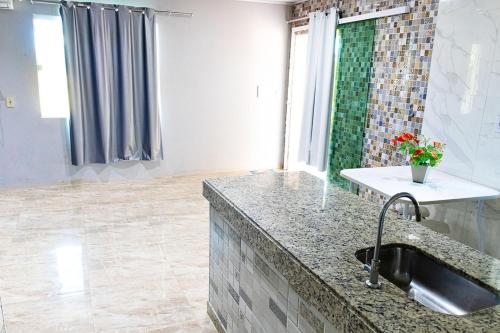 eine Küche mit Spüle und Arbeitsplatte in der Unterkunft Casa aconchegante com piscina em Camacari BA in Camassari