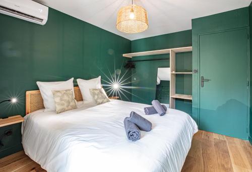 - une chambre avec un grand lit blanc aux murs verts dans l'établissement Le POP FLAT by Winkyhouse Cassis, à Cassis