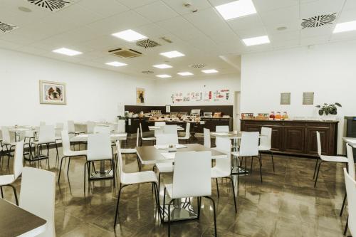 a dining room with white tables and white chairs at Hotel Carpi in Carpi