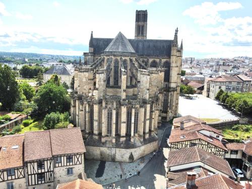 een oude kathedraal in een stad met daken bij Bel appartement en plein centre ville in Limoges