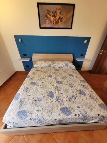 a bedroom with a bed with a blue head board at CASA NICCA in Oleggio