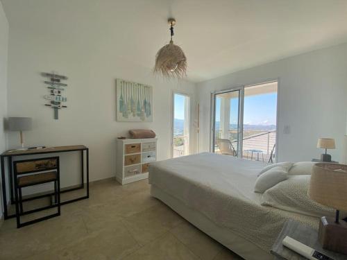 - une chambre avec un lit et une table avec une fenêtre dans l'établissement Villa de charme à louer en Corse, piscine chauffée, à Oletta